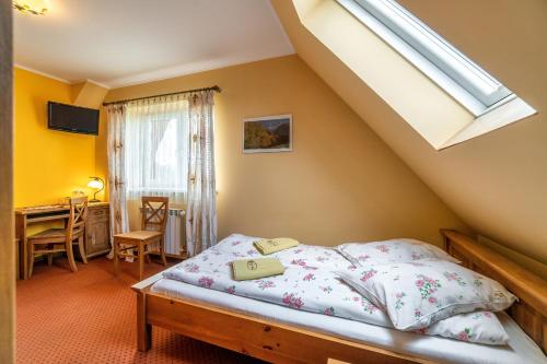 a bedroom with a bed and a window and a desk at Willa Paula in Ząb