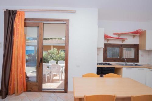 uma cozinha com uma porta aberta para um pátio em Villetta Porto Corallo Vista Mare em Villaputzu