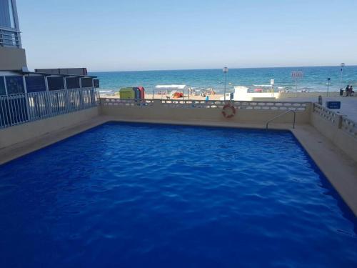 una piscina con la playa de fondo en Un Rincon en el Mar, en Bellreguart