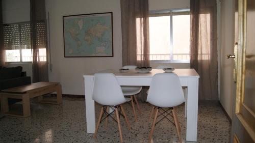 a white table and two white chairs in a room at Dona Branca in Quiroga