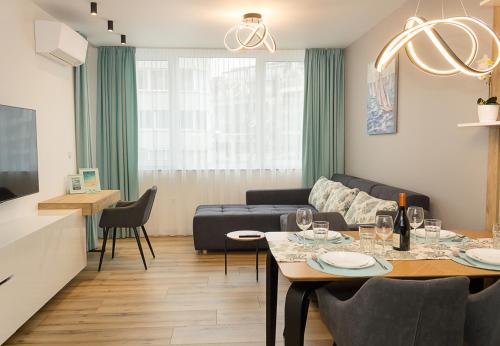 sala de estar con mesa y sofá en Modern Seaside Retreat 1BD Apartments, en Varna