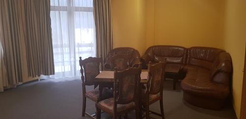 - un salon avec une table, des chaises et un canapé dans l'établissement Vila Predeal Holidays, à Predeal