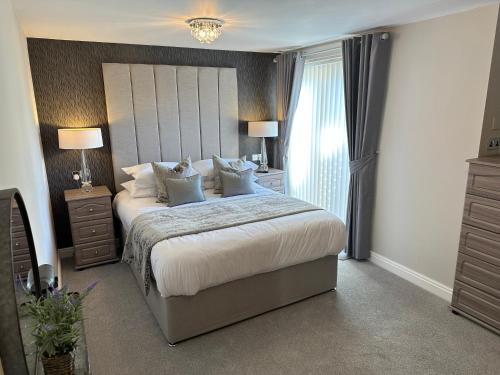 a bedroom with a bed with two night stands and a window at Beach Pad - ground floor - pet friendly in Cleveleys