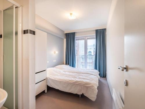 ein kleines Schlafzimmer mit einem Bett und einem Fenster in der Unterkunft Attractive apartment in Koksijde with balcony in Koksijde