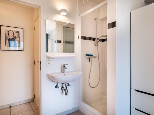 ein Bad mit einem Waschbecken und einer Dusche in der Unterkunft Attractive apartment in Koksijde with balcony in Koksijde