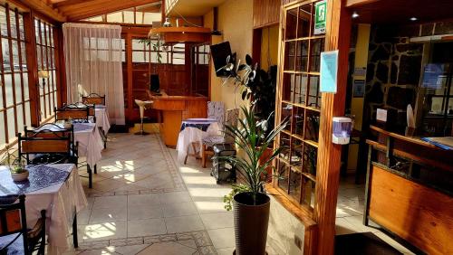 a restaurant with tables and a plant in a room at Hotel Boutique 3 Poniente in Viña del Mar