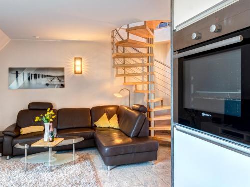 ein Wohnzimmer mit einem Sofa und einem TV in der Unterkunft Residenz am Balmer See - BS 67 mit Wellnessbereich in Balm
