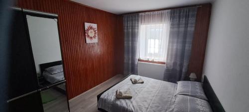 a small bedroom with a bed and a window at Apartman Regina in Sunger