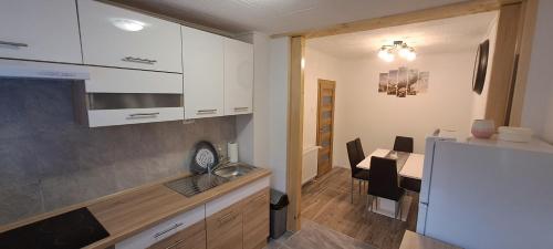 a kitchen and dining room with a table in the background at Apartman Regina in Sunger