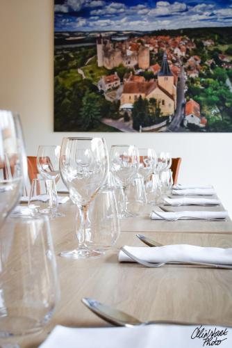 a table with wine glasses and napkins on it at Hostellerie Du Chateau in Châteauneuf