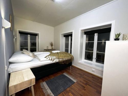 a bedroom with a bed and two windows at Stavanger Bnb billiard Sauna in Stavanger