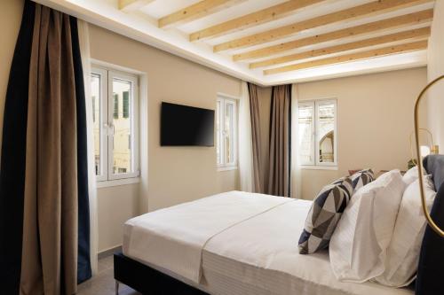 a bedroom with a bed and two windows at Vittori Corfu Rooms in Corfu