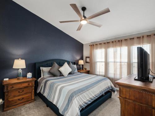 a bedroom with a bed and a ceiling fan at Mickey's Splash Pad, 2 Miles To Disney in Orlando