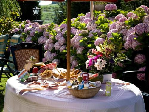 Maoño的住宿－Hostería los Sauces，一张桌子,上面放着一篮子的食物和紫色的鲜花