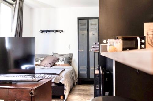 a small bedroom with a bed and a desk at LE PTIT LOCMARIA - Calme - Wifi - Proche Centre ville in Quimper