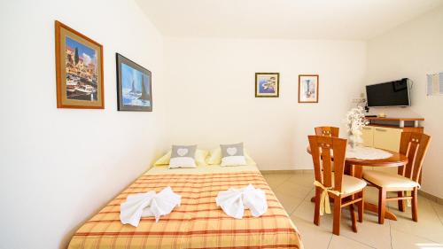 a bedroom with a bed and a dining room table at Apartments Mija in Bol