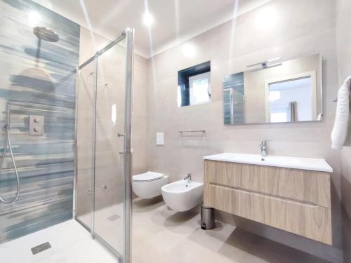 een badkamer met een douche, een wastafel en een toilet bij Casa Vacanze Onda Azzurra (Deluxe) in Peschici