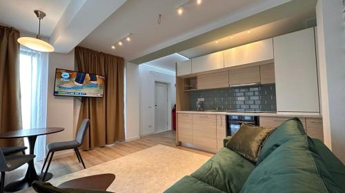 ヤシにあるCubrio Apartmentsのリビングルーム(緑のソファ付)、キッチンが備わります。