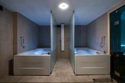 y baño con 2 bañeras y ducha. en Emery Hotel en Pristina