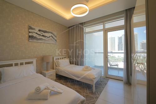 a hotel room with two beds and a balcony at KeyHost - Classy 2BR Apartment near to Five Hotel - JVC - K550 in Dubai