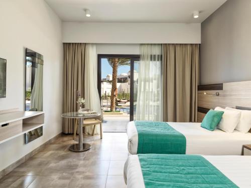 a hotel room with two beds and a patio at Ancient Sands Golf Resort and Residences in Hurghada