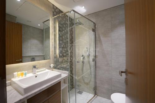 a bathroom with a sink and a glass shower at KeyHost - Classy 2BR Apartment near to Five Hotel - JVC - K550 in Dubai