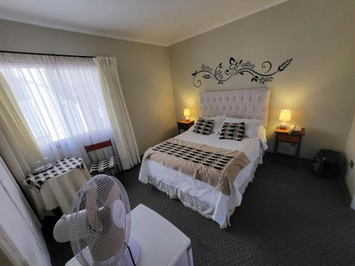 a bedroom with a bed and a fan in it at Hotel Boutique 3 Poniente in Viña del Mar