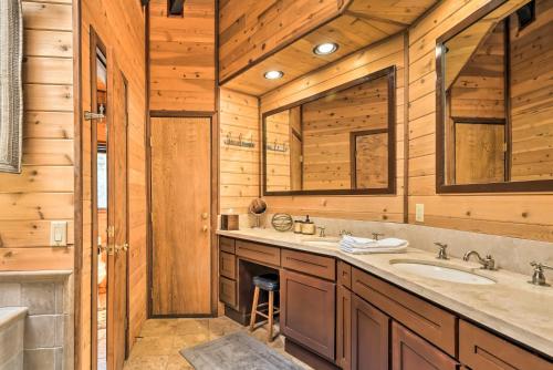 un baño con lavabo y dos espejos en Cozy Grand Woodland Cabin with Mountain Views, en Pine Mountain Club