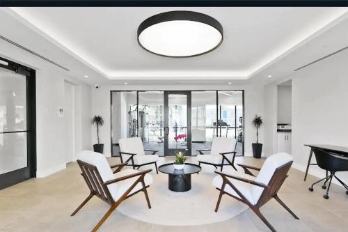 a living room with chairs and a table and a piano at Lux property great for 1 to 8 Guests-family trip ,5Beds 2Rooms Staycation with Gym and EV, proximity to Downtown and Beaches in West Palm Beach