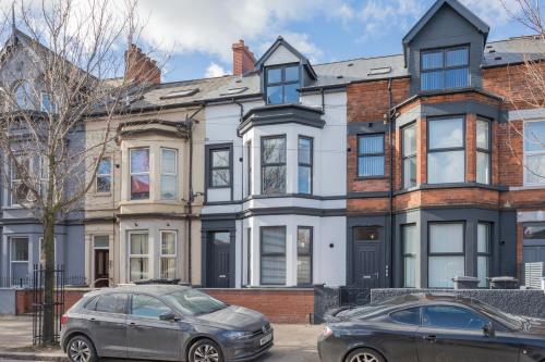 a house with two cars parked in front of it at Capital East Apartment in Belfast