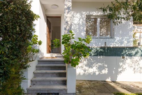 a white house with stairs and a window at Villas Boas House Caparica in Costa da Caparica