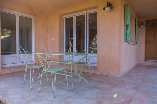 une table et des chaises assises sur une terrasse couverte dans l'établissement Appartement T2 rez de villa, à Saint-Florent