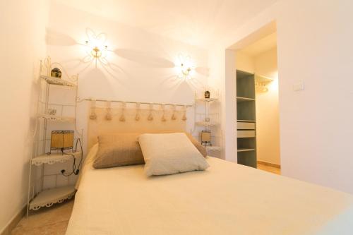 a bedroom with a bed with two lights on the wall at Appartement T2 rez de villa in Saint-Florent