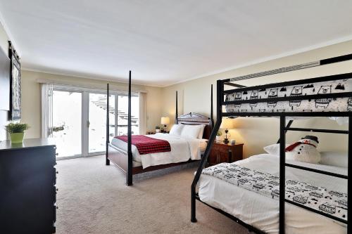 キリングトンにあるThe Birch Ridge- Family Room #6 - Queen Bunkbed Suite in Killington, Vermont Hotel Roomのベッドルーム1室(二段ベッド2組付)、バルコニーが備わります。