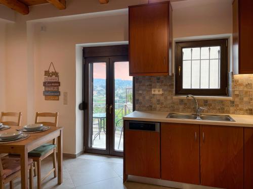 een keuken met een wastafel en een tafel met een raam bij La Casa Di Manou in Plataniás