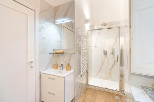 a white bathroom with a shower and a sink at Domus Decumana in Naples