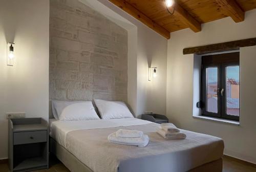 een slaapkamer met een bed met twee handdoeken erop bij La Casa Di Manou in Plataniás