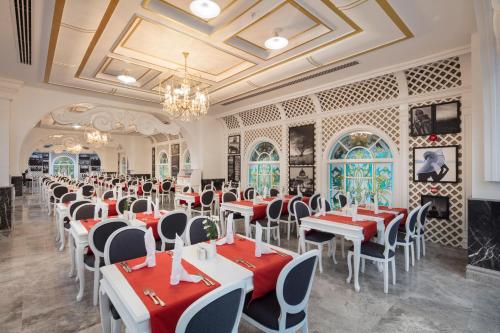 ein Esszimmer mit roten und weißen Tischen und Stühlen in der Unterkunft Granada Luxury Beach-Ultra All Inclusive in Avsallar