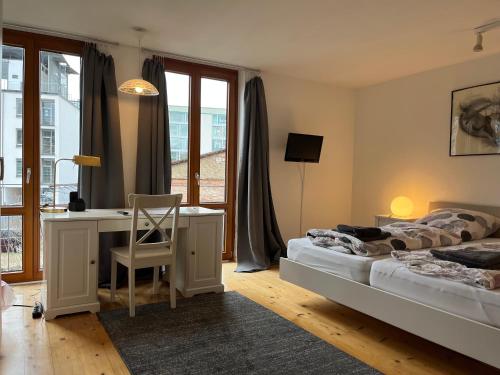 a bedroom with two beds and a desk and a window at Haus Schönwald in Freiburg im Breisgau