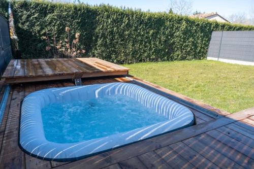 une grande baignoire bleue posée sur une terrasse en bois dans l'établissement Maison Les portes de l'Océan avec jacuzzi 8/10P, à Sainte-Hélène