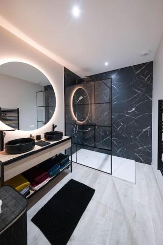 une salle de bain avec un lavabo et un miroir dans l'établissement Maison Les portes de l'Océan avec jacuzzi 8/10P, à Sainte-Hélène