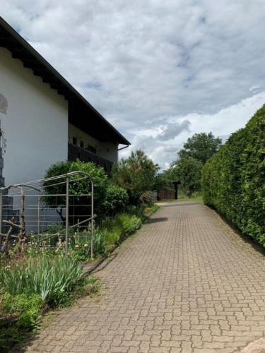 een bakstenen weg naast een gebouw met een hek bij Gästezimmer - Mespelbrunn in Mespelbrunn