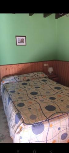 a bed with a quilt on it in a bedroom at La casina de castiello in Arriondas