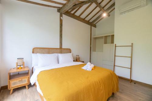 1 dormitorio con 1 cama grande con manta amarilla en Singgah di Ubud 1 en Ubud