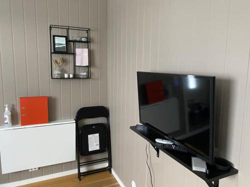 a flat screen tv sitting on top of a wall at Apartment Tromsdalen. Tromsø in Tromsø