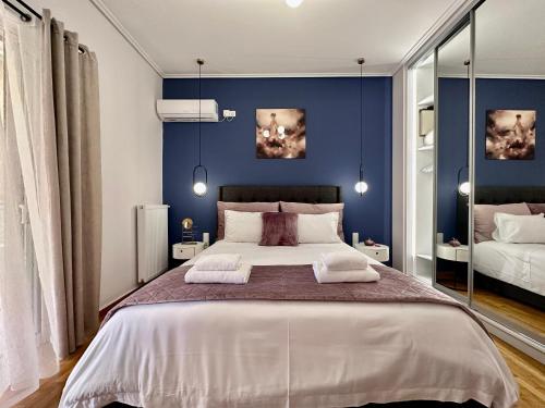 a bedroom with a large bed with blue walls at Elaia Luxury Selections Sapphire in Athens