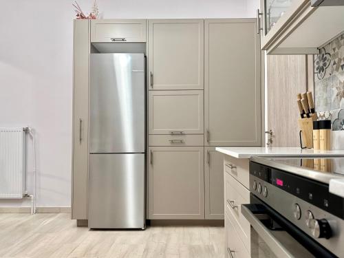 a stainless steel refrigerator in a kitchen with white cabinets at Elaia Luxury Selections - Sapphire Apartment in Athens
