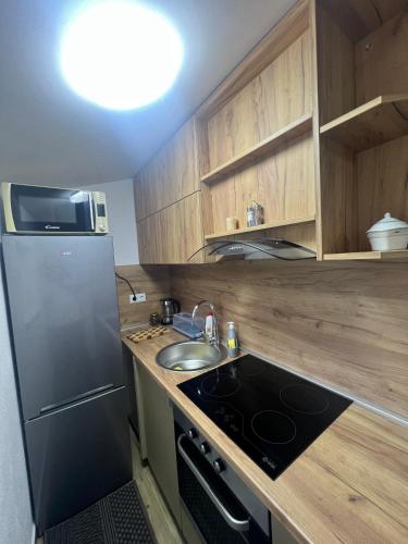 a small kitchen with a sink and a refrigerator at Apartman Eden in Brčko