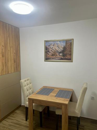 布爾奇科的住宿－Apartman Eden，一间设有桌子和墙上绘画的用餐室