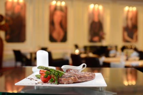 a plate of meat and vegetables on a table at Grand Hotel Bucharest in Bucharest